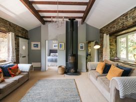 A living room with sofas, a fireplace and a rug at The Old Barn in Ciliau Aeron near Aberaeron