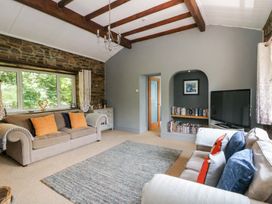 A living room with a sofa and television at The Old Barn in Ciliau Aeron near Aberaeron