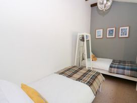 A bedroom with two beds and wall art at The Old Barn in Ciliau Aeron near Aberaeron