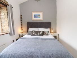 A bedroom with a bed and bedside table at The Old Barn in Ciliau Aeron near Aberaeron