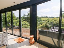 A conservatory with views of the landscape at The Old Barn in Ciliau Aeron near Aberaeron