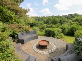 A seating area with a fire pit surrounded by plants at The Old Barn in Ciliau Aeron near Aberaeron