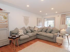 A living room with a sofa, side table and lamp at The Threshing Barn in Chipping Norton
