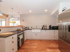 A kitchen with white cabinets and stainless steel appliances at The Threshing Barn in Chipping Norton