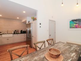 A kitchen with dining table and refrigerator at The Threshing Barn in Chipping Norton