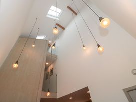 A hallway with hanging light fixtures and skylights at The Threshing Barn in Chipping Norton