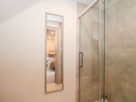 A bathroom with a mirror and a shower at The Threshing Barn in Chipping Norton