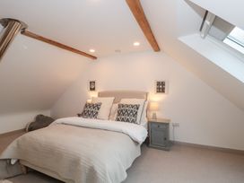 A bedroom with a bed and a nightstand at The Threshing Barn in Chipping Norton