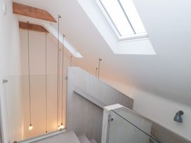 A stairwell with skylight and glass railing at The Threshing Barn in Chipping Norton