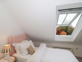 A bedroom with a bed and lamp at The Threshing Barn Chipping Norton