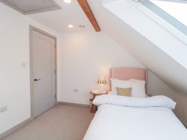 A bedroom with a bed and bedside table at The Threshing Barn in Chipping Norton