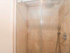 A shower with glass door and chrome fixtures at The Threshing Barn Chipping Norton