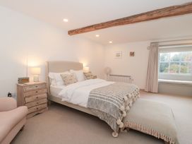 A bedroom with a bed and side table at The Threshing Barn Chipping Norton