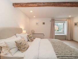 A bedroom with a bed and window at The Threshing Barn in Chipping Norton