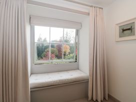 A window with a bench and curtains at The Threshing Barn in Chipping Norton