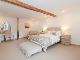 A bedroom with a bed and a dressing table at The Threshing Barn in Chipping Norton