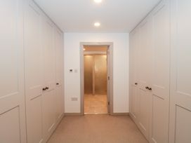 A hallway with wardrobes and a door leading to another room at The Threshing Barn in Chipping Norton