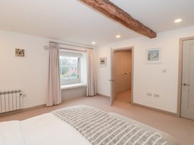 A bedroom with a window and door at The Threshing Barn in Chipping Norton