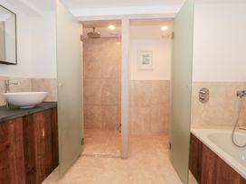 A bathroom with a shower and bathtub at The Threshing Barn in Chipping Norton