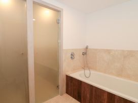 A bathroom with a bathtub and shower at The Threshing Barn Chipping Norton