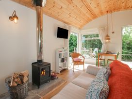 A living room with a wood stove and a dining area at Squirrel's Drey Chapel Lawn near Clun