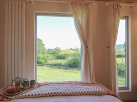 A bedroom with a bed and window view at Squirrel's Drey Chapel Lawn near Clun