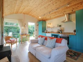 A kitchen with a sofa and dining table at Squirrel's Drey in Chapel Lawn near Clun