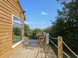 An outdoor seating area with a table and chairs at Squirrel's Drey Chapel Lawn near Clun
