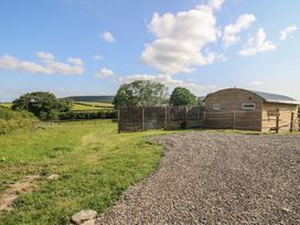 An outdoor area with a building and fence at Squirrel's Drey Chapel Lawn near Clun