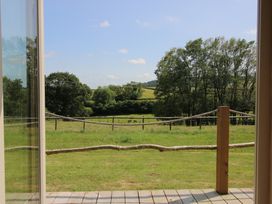 A view of a grassy area with trees and a fence at Owl's Hollow Chapel Lawn near Clun