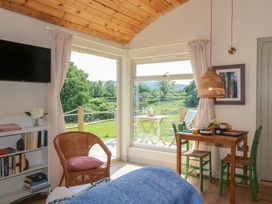 A living room with a table and chairs at Owl's Hollow Chapel Lawn near Clun