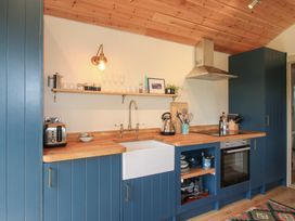 A kitchen with a sink, kettle, and toaster at Owl's Hollow Chapel Lawn near Clun