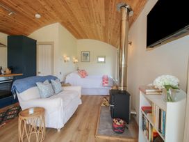 A living room with a couch and wood stove at Owl's Hollow Chapel Lawn near Clun