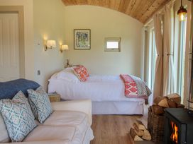 A bedroom with a bed and sofa at Owl's Hollow in Chapel Lawn near Clun