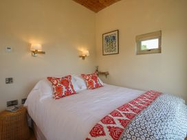 A bedroom with a double bed and wall art at Owl's Hollow Chapel Lawn near Clun