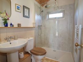 A bathroom with a shower, sink, and toilet at Owl's Hollow, Chapel Lawn near Clun
