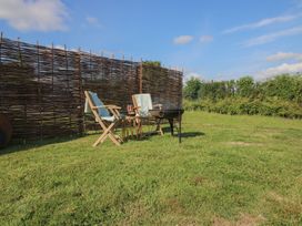 A garden with chairs and a fire pit at Owl's Hollow Chapel Lawn near Clun