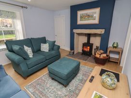 A living room with a sofa and fireplace at Linn Cottage in Hexham