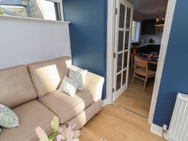 A living room with a couch and a door leading to the kitchen at Linn Cottage in Hexham
