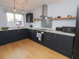 A kitchen with cabinets and appliances at Linn Cottage Hexham