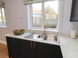 A kitchen with a sink and a bowl of fruit at Linn Cottage in Hexham