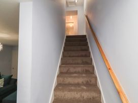A staircase with carpet and a handrail at Linn Cottage in Hexham