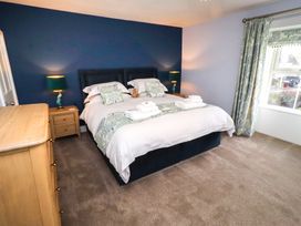 A bedroom with a bed and nightstand at Linn Cottage Hexham