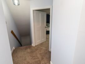A hallway with a staircase and a door at Linn Cottage in Hexham