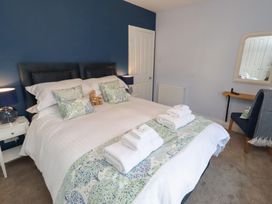 A bedroom with a bed and nightstand at Linn Cottage in Hexham