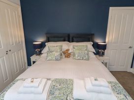 A bedroom with a bed and bedside lamps at Linn Cottage in Hexham