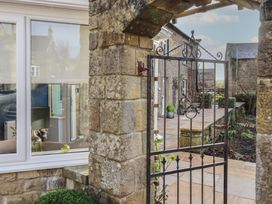 A garden with a stone gate and pathway at Linn Cottage in Hexham
