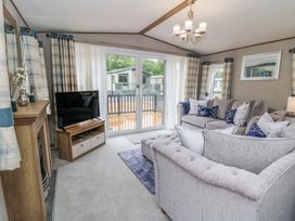 A living room with a sofa and television at The Beaumont No 34 in New Quay