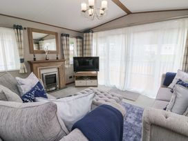 A living room with a sofa and television at The Beaumont No 34 in New Quay