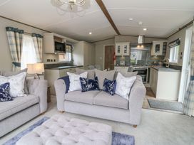 A living room with a sofa and kitchen area at The Beaumont No 34 New Quay